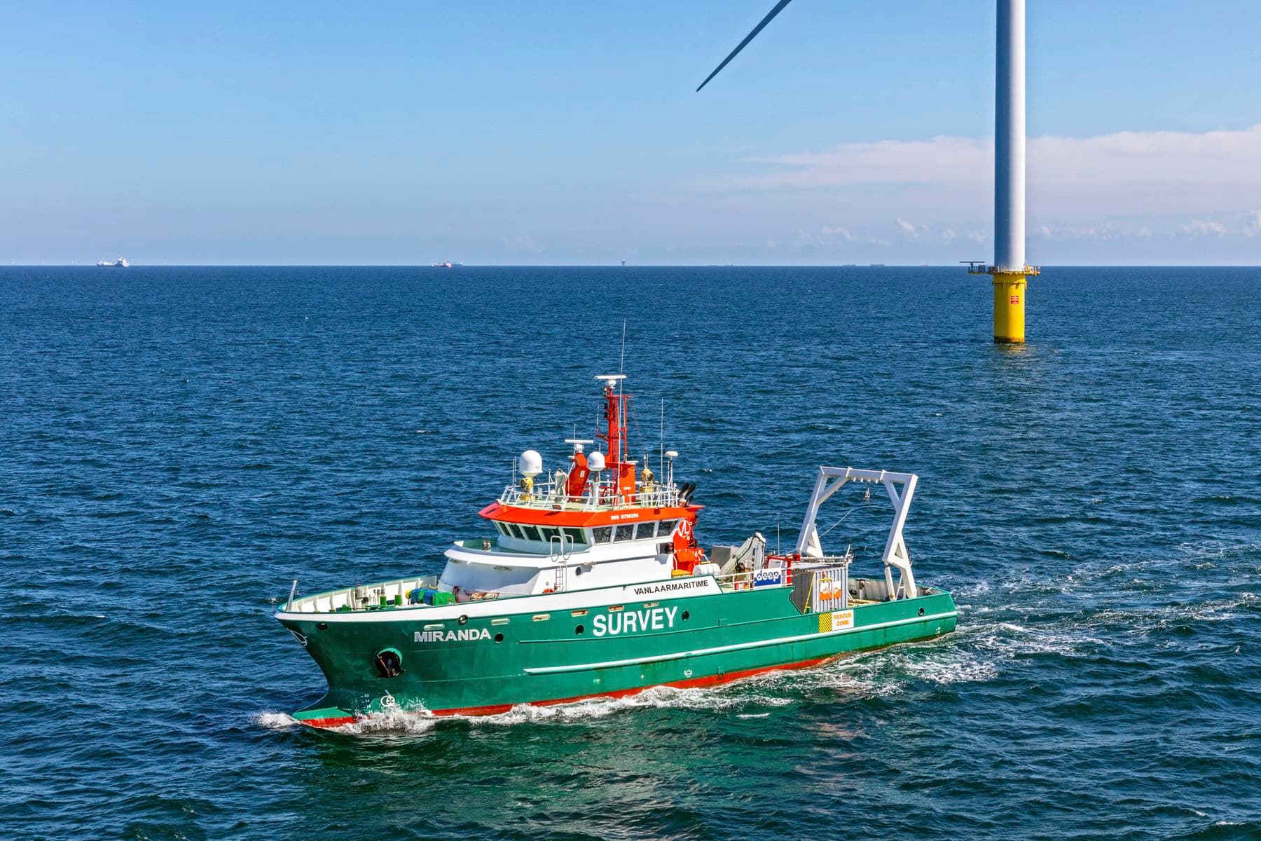 Survey Vessel Miranda in action next to a wind turbine at sea.